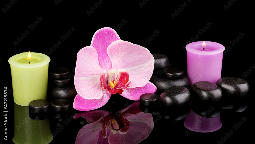 Spa stones with orchid flower and candles isolated on black Spa stones with orchid flower and candles isolated on black