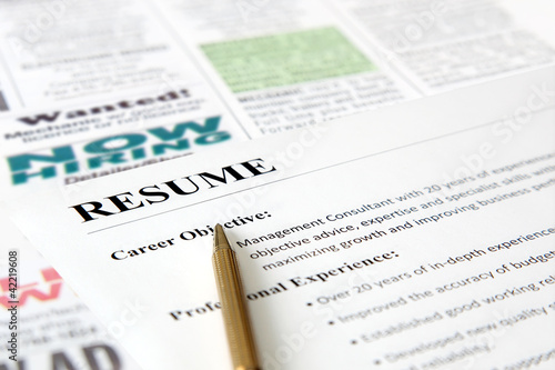 Closeup of resume with pen on the newspaper