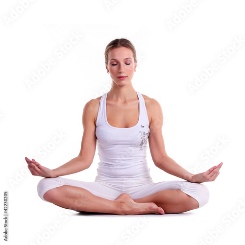Young woman practicing yoga, sitting in a lotus position