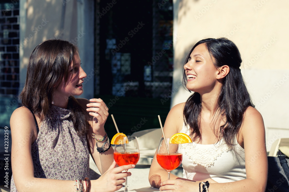 two young girls while they take a cocktail two young girls while they take a cocktail