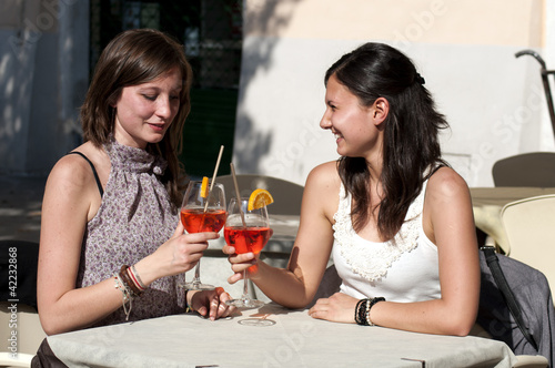 two young girls while they take a cocktail