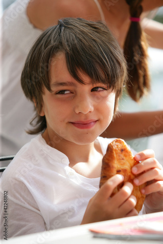 Boy eating a croissant