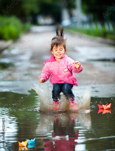 girl jumps into a puddle