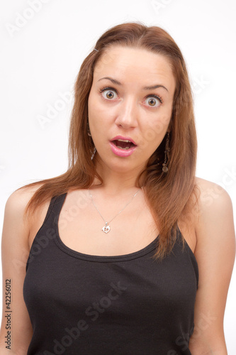 Pretty girl makes a grimace on his face on a white background.
