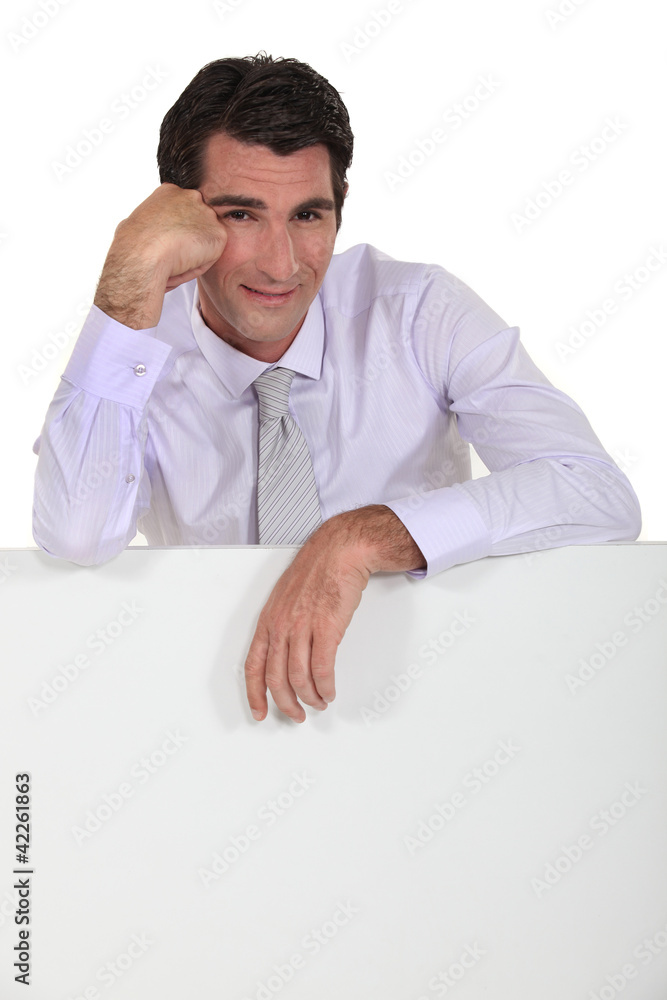 Man leaning on white panel Man leaning on white panel