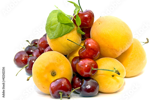 Fresh apricots and sweet cherries with the leaves of mint