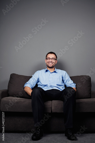 Man sitting on sofa © baranq