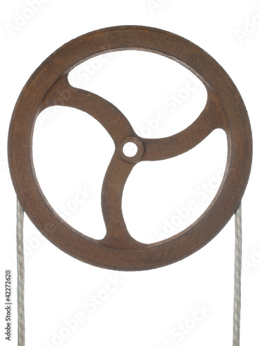 Old rusty pulley with a rope thrown, isolated on white.