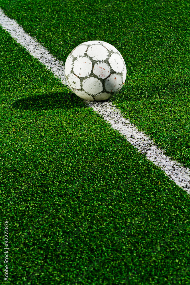 Old soccer ball on green grass