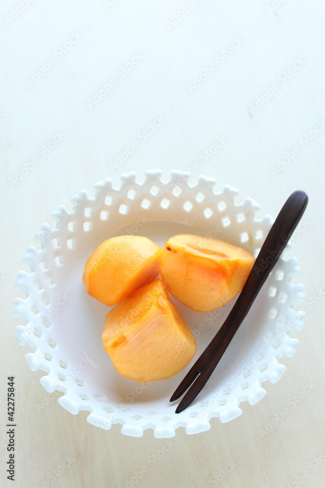 Cut fruit, persimmon on white background with copy space Cut fruit, persimmon on white background with copy space