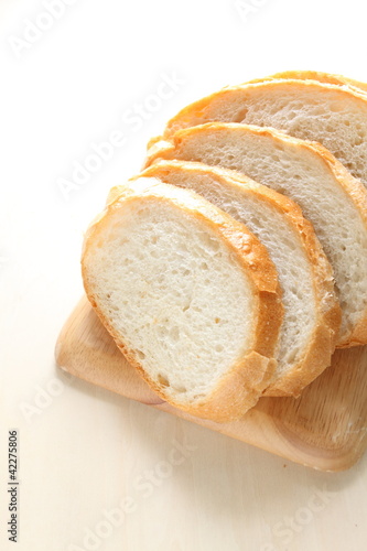 Slided french bread on wooden chopping board