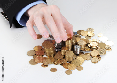 Businessman hand put coins isolated on white