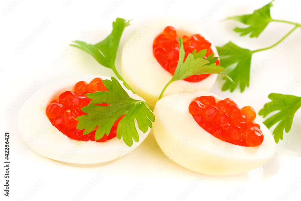 Red caviar in eggs on white plate close-up Red caviar in eggs on white plate close-up