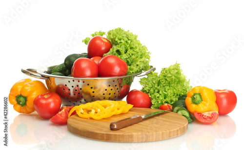 fresh vegetables and knife on cutting board isolated on white