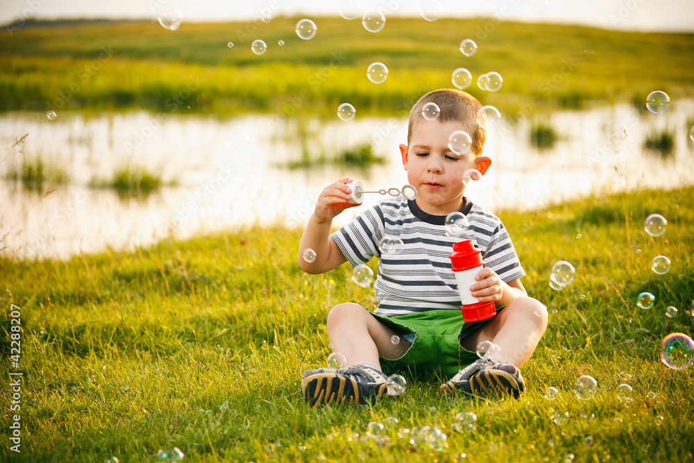 Boy sitting on green grass Boy sitting on green grass