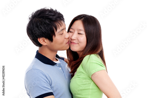 Happy couple hugging and kissing over white background