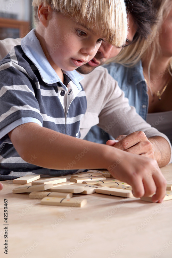 Young boy playing dominoes with his father Young boy playing dominoes with his father
