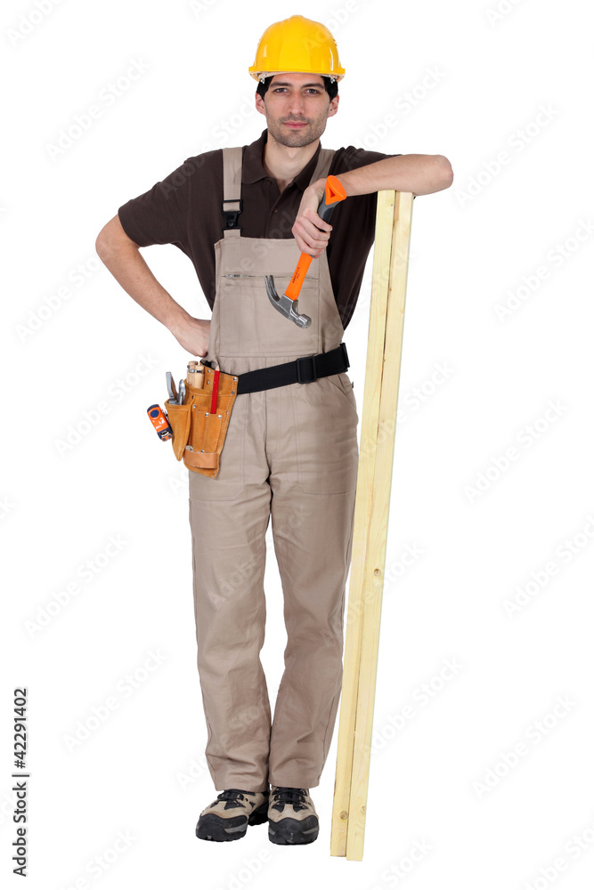 Man stood with plank of wood and hammer Man stood with plank of wood and hammer