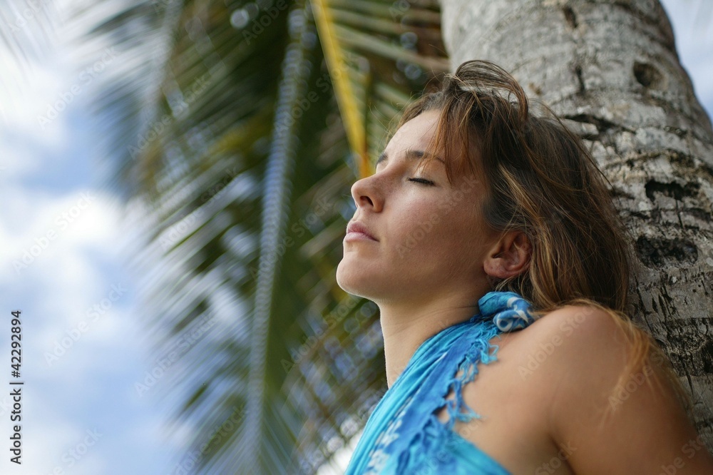 Woman leaning against palm tree Woman leaning against palm tree