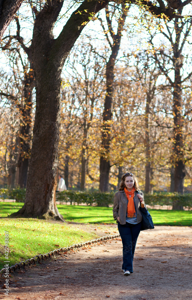 Beautiful young woman enjoying warm autumn day in park Beautiful young woman enjoying warm autumn day in park
