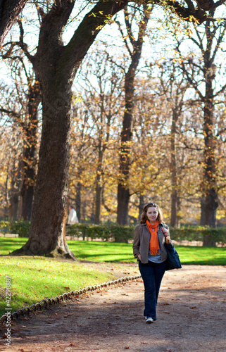 Beautiful young woman enjoying warm autumn day in park © Ekaterina Pokrovsky