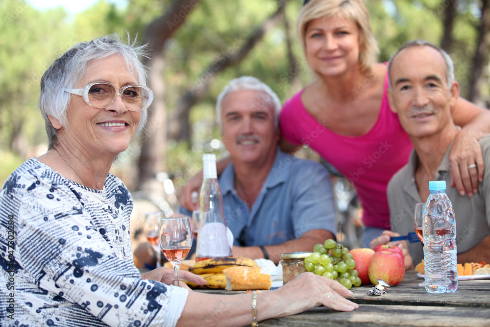 Senior woman having a picnic with friends Senior woman having a picnic with friends