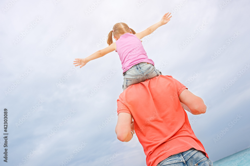 Father carrying his daughter on shoulders Father carrying his daughter on shoulders