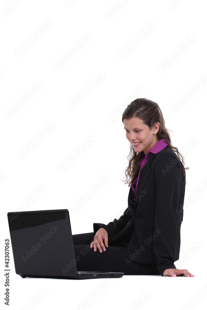 Woman sitting on the floor looking at computer Woman sitting on the floor looking at computer
