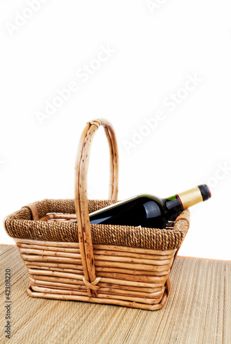 picnic basket with bottle of red dry wine studio shot