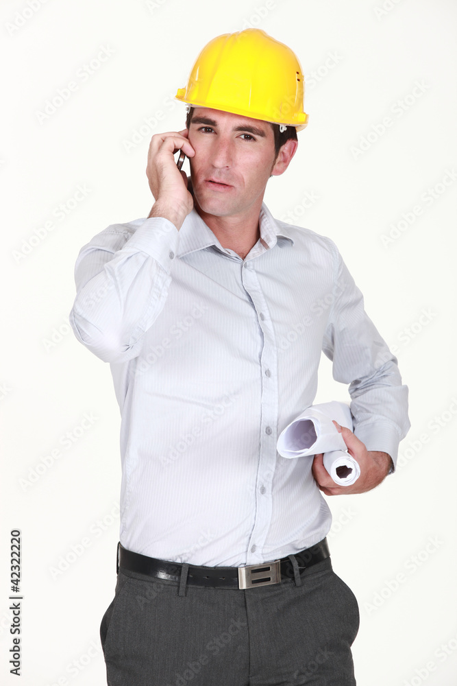 architect holding rolled-up plans and phone