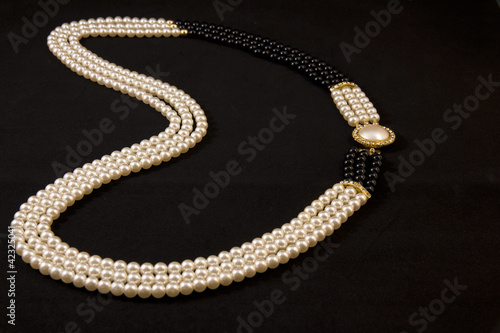 Necklace of pearls on black background