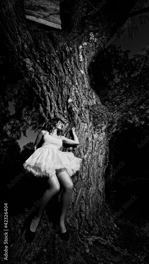 beautiful girl leaned against a large tree