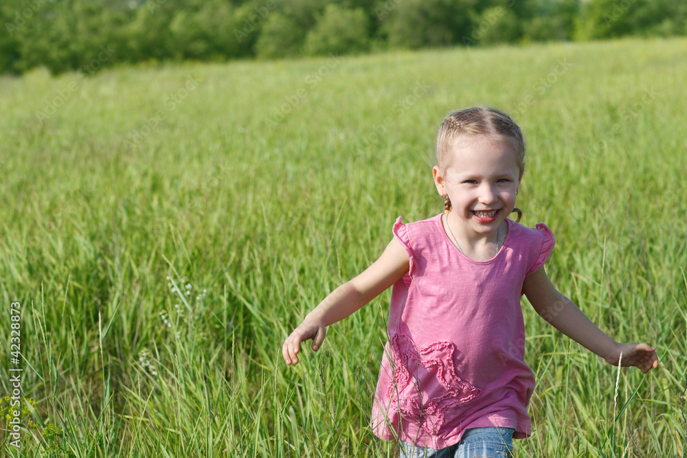Happy little child running in the field over green grass Happy little child running in the field over green grass