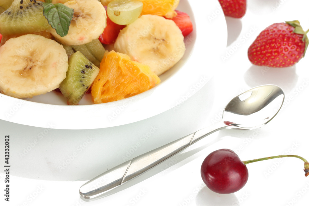 Fresh fruits salad on plate and berries isolated on white Fresh fruits salad on plate and berries isolated on white