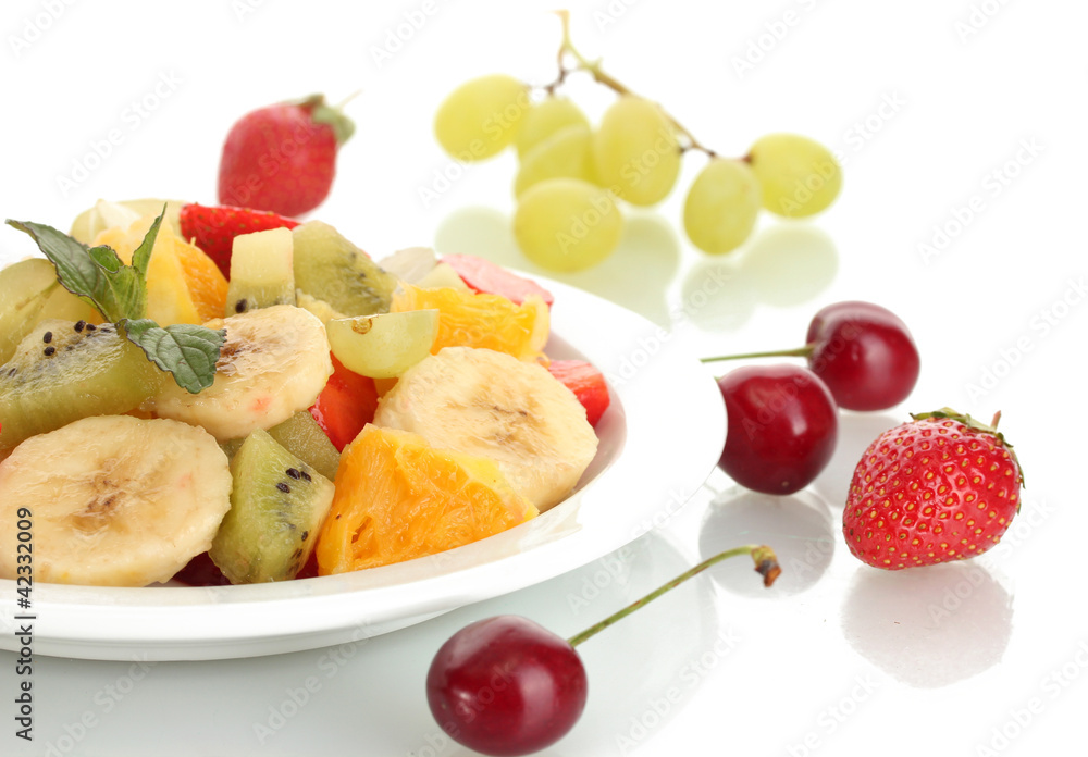 Fresh fruits salad on plate and berries isolated on white Fresh fruits salad on plate and berries isolated on white