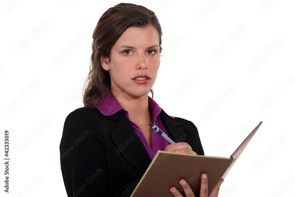 Businesswoman writing in her agenda Businesswoman writing in her agenda