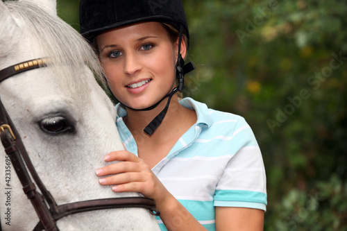 Young woman caressing her horse
