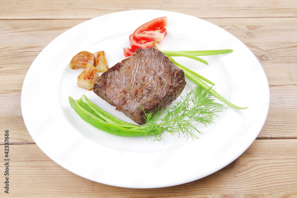 meat food : roasted fillet mignon on white plate with tomatoesan meat food : roasted fillet mignon on white plate with tomatoesan