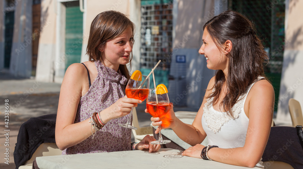Two Young Women Cheering with Cold Drinks Two Young Women Cheering with Cold Drinks