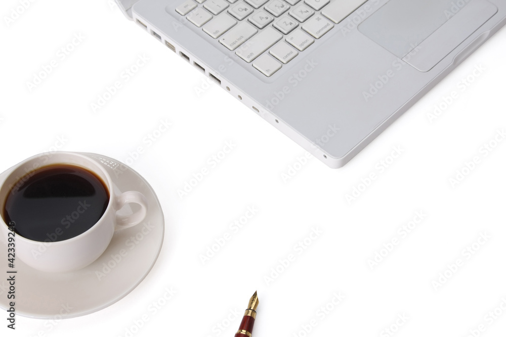 A cup of coffee and a pen near a laptop A cup of coffee and a pen near a laptop