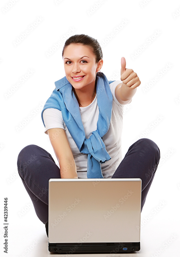A woman with a thumb up sign working with a laptop A woman with a thumb up sign working with a laptop