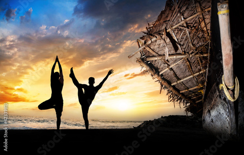 Yoga silhouettes on the beach photo