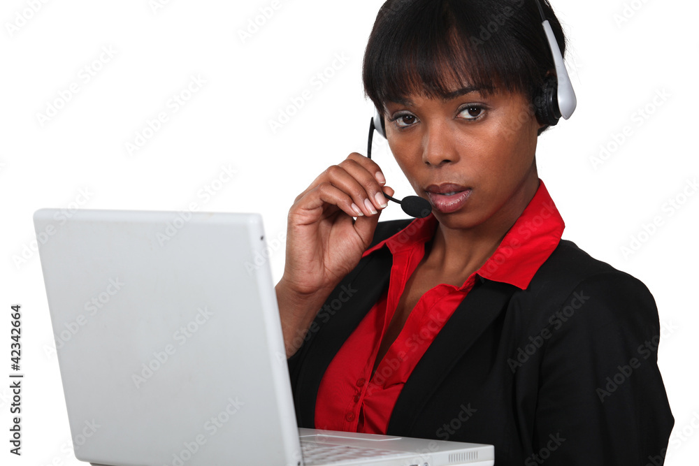 Secretary speaking into her headset and holding a laptop Secretary speaking into her headset and holding a laptop