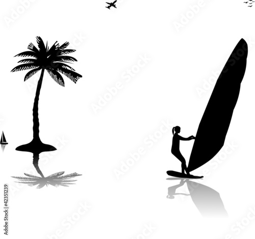 Silhouettes of woman windsurfer at the sunset near the palm tree