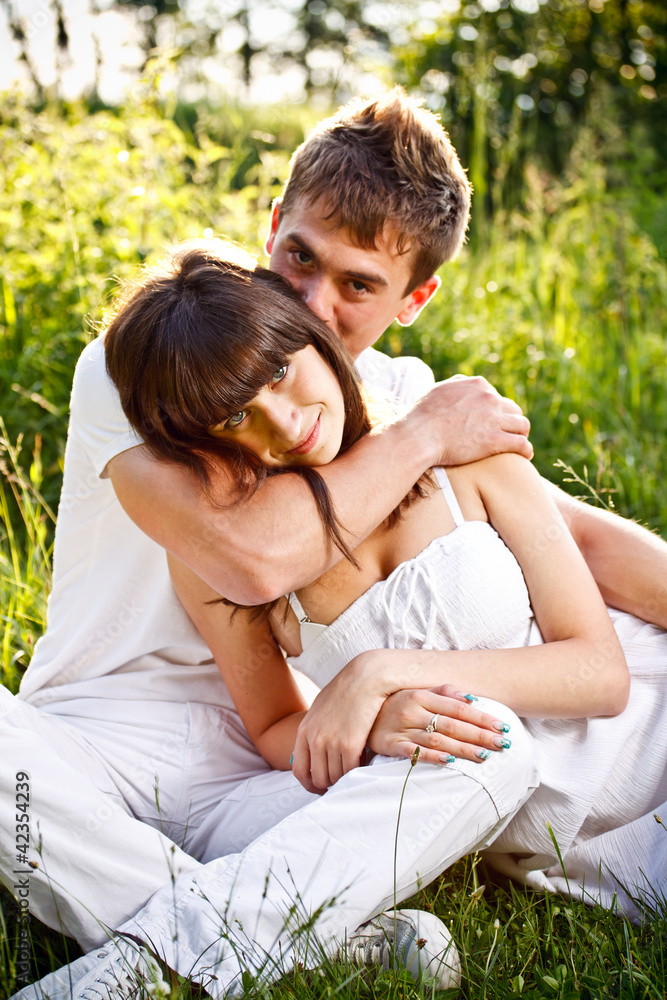 Young couple sitting on ground in park Young couple sitting on ground in park