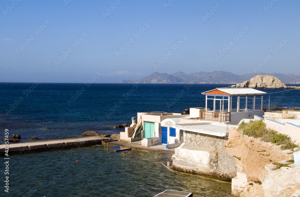 houses built into rock cliffs on Mediterranean Sea Firopotamos