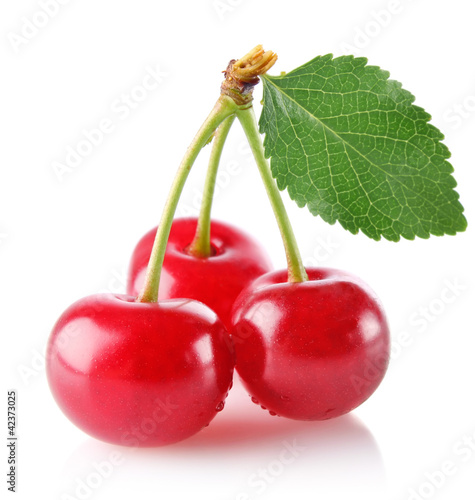 three sweet juicy cherry with green leaf isolated on white