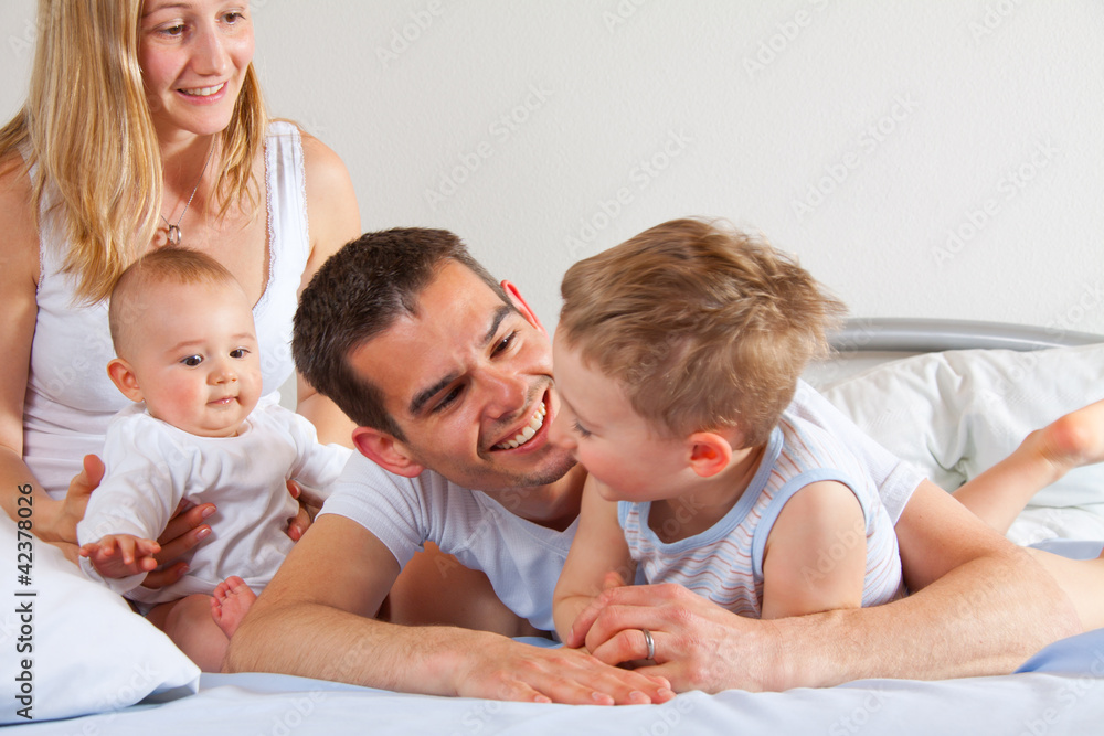 Glückliche Familie kuschelt im Bett Glückliche Familie kuschelt im Bett