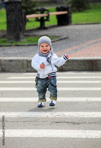 Little boy crossing a street