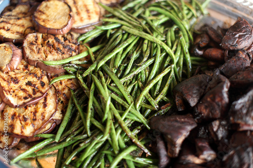Grilled mushrooms, green beans, and eggplant on a tray.